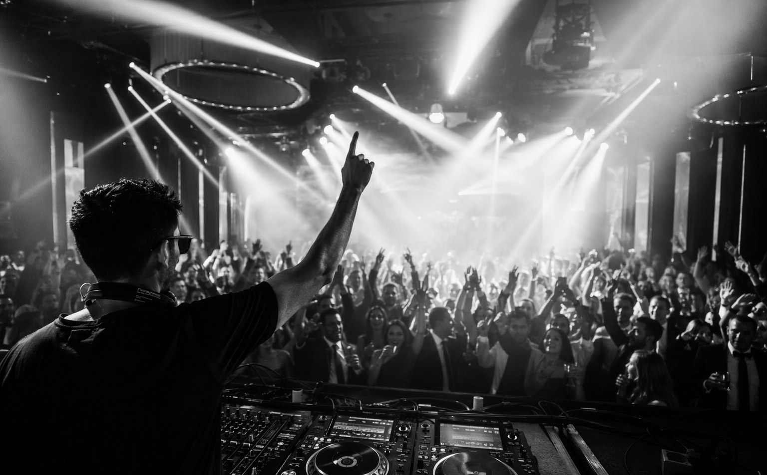 DJ performing at a Singapore corporate event with a packed dance floor and dynamic lighting